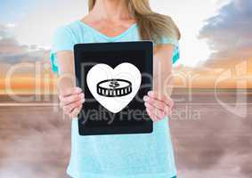 Woman holding tablet with money in heart icon
