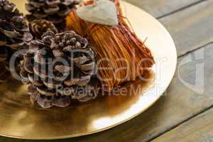 High angle  view of pine cones with thread in plate