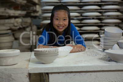 Portrait of happy girl sitting at worktop