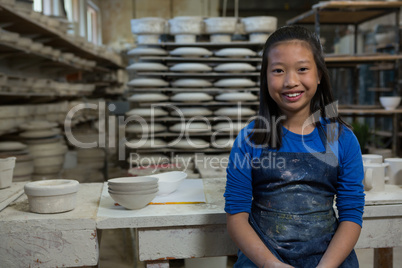 Portrait of happy girl standing near worktop