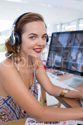 Smiling female executive in headset at his desk in office