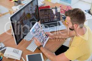 Male executive looking at photos at desk