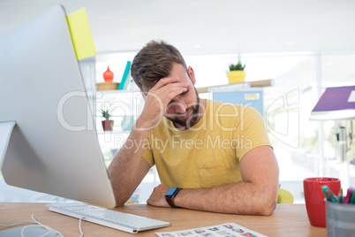 Depressed male executive working on computer