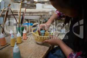 Girl decorating painting bowl