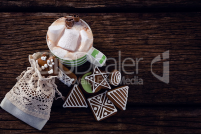Various cookies and hot chocolate on wooden plank