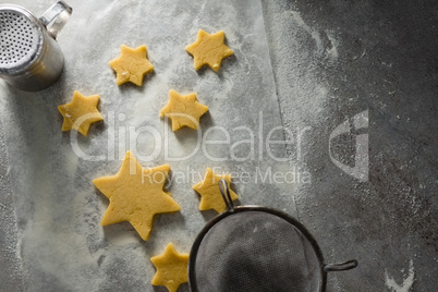 Star shape cookies on flour with strainer