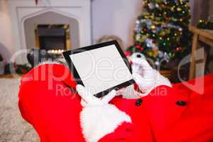 Santa claus sitting and using digital tablet