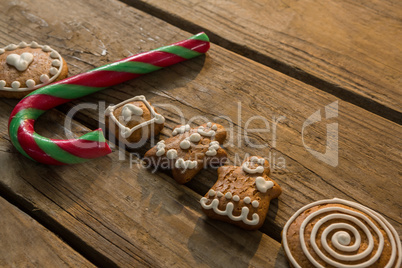 High angle view view of candy cane with gingerbread cookies arranged on table