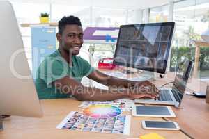 Smiling executive working on laptop in office