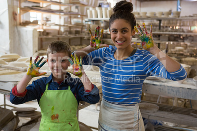 Mother and son showing colorful paint on their hands