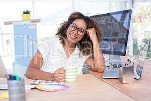 Portrait of female executive holding a cup of coffee in office
