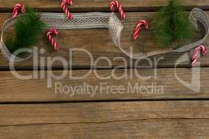 High angle view of candy canes with twigs and ribbon on table