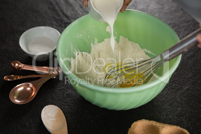 Woman whisking flour in bowl