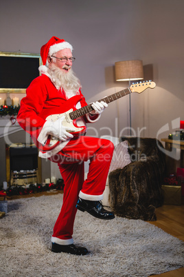 Smiling santa claus playing a guitar