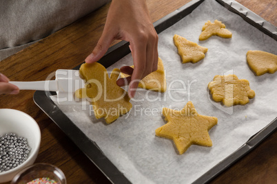 Man placing gingerbread cookies in baking tray