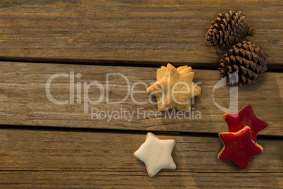 Overhead view of star shaped cookies with pine cones on table