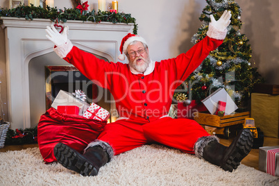 Excited santa claus sitting on rug in living room