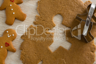 Gingerbread dough with cookie cutter on wooden table