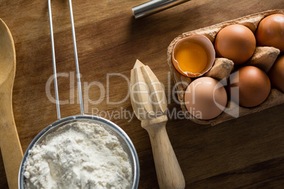 Flour, eggs and spoon placed on a table