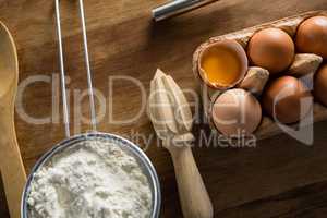 Flour, eggs and spoon placed on a table