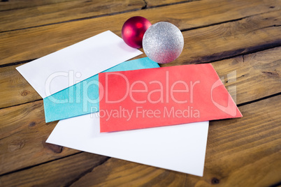 Envelopes and christmas baubles on wooden table