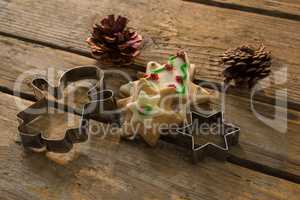 High angle view of cookies with pine cones and pastry cutters on table