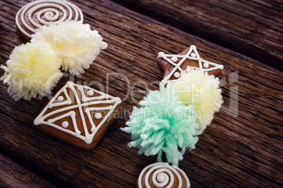 Various christmas cookies and decorations arranged on wooden plank