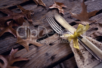Tied knife and fork on wooden table