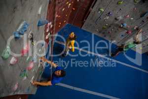 View of athletes examining climbing wall in health club