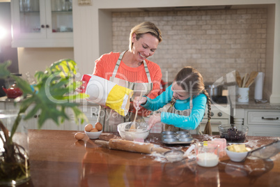 Mother and daughter preparing cookies in kitchen