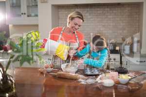 Mother and daughter preparing cookies in kitchen