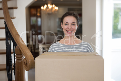 Woman carrying cardboard boxes in living room