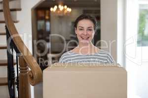 Woman carrying cardboard boxes in living room