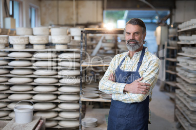 Portrait of male potter standing with arms crossed