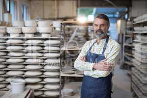 Portrait of male potter standing with arms crossed