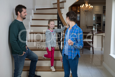 Parents and daughter standing on stairs