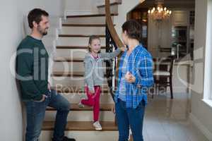 Parents and daughter standing on stairs
