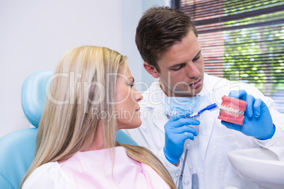 Dentist showing dental mold to woman