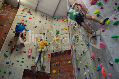 View of athletes rock climbing in health club