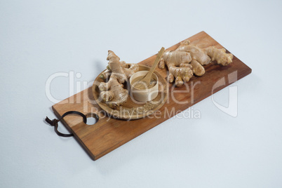 Organic gingers and powder on wooden serving board