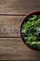 Overhead view of fresh kale in colander on table