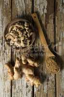 Overhead view of gingers with powder and wooden spoon on table