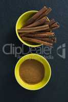Cinnamon sticks and powder in a bowl