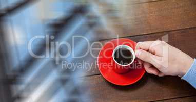Overhead of hand with red coffee cup and blurry window transition