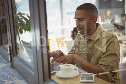 Man using laptop seen through glass window Man using laptop seen through glass window