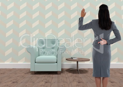 Businesswoman with fingers crossed in quirky wallpapered room with armchair