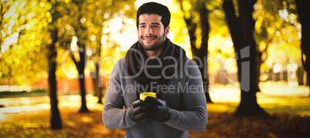 Composite image of smiling man looking away while holding mug of coffee