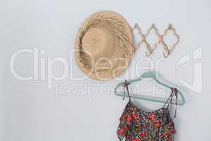 Hat and dress hanging against white wall