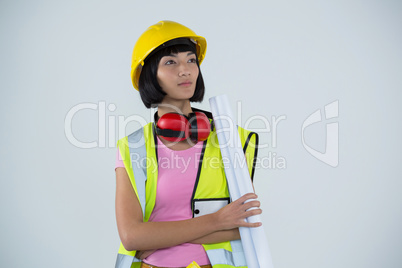 Female architect holding blueprint against white background