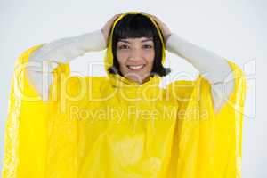 Woman wearing yellow raincoat against white background